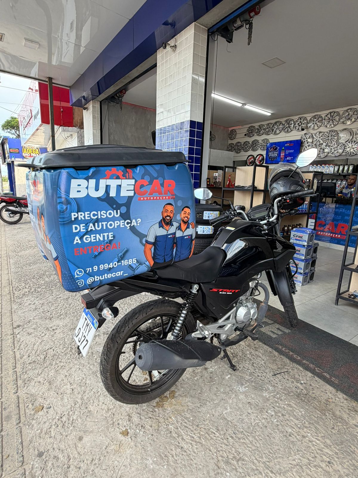 Moto de delivery da Butecar em frente à loja