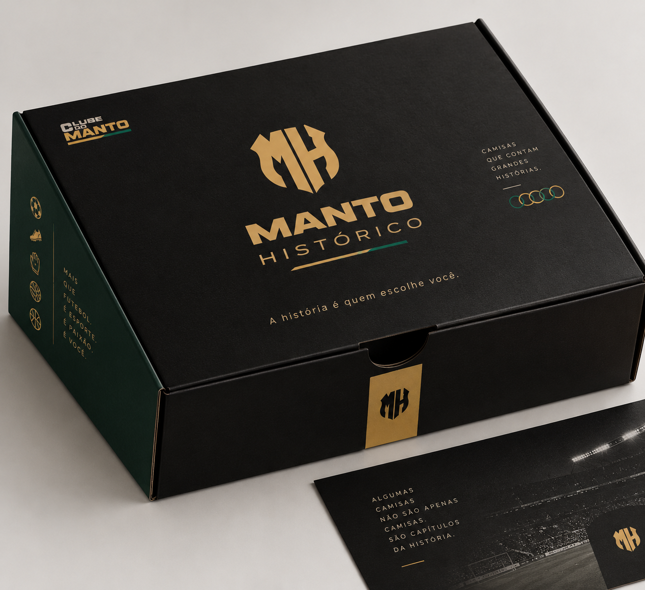 Caixa preta do Manto Histórico com logotipo dourado MH, a frase "A história é quem escolhe você." e lateral verde