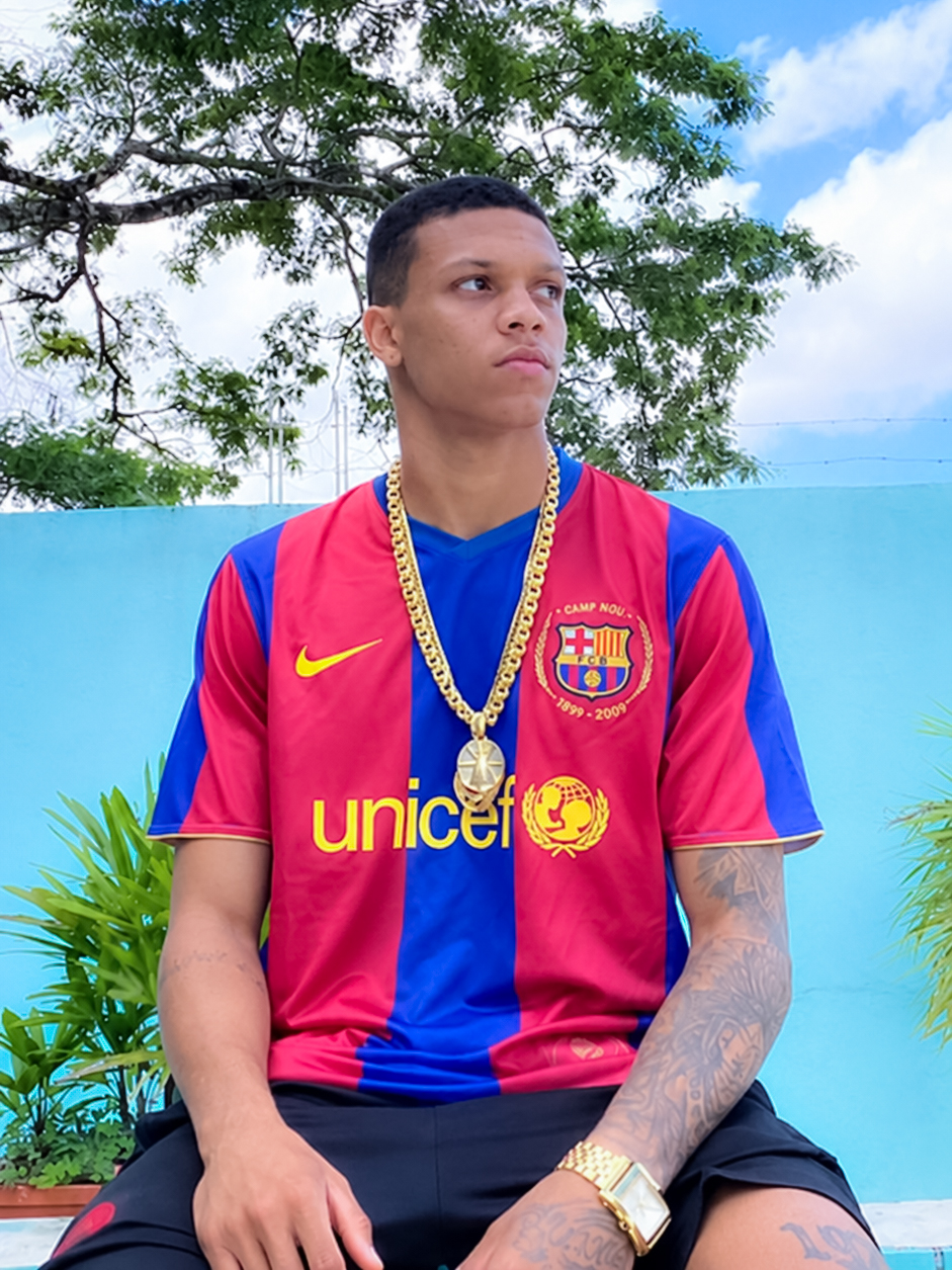 Rapaz sentado vestindo camisa retrô listrada em azul e grená