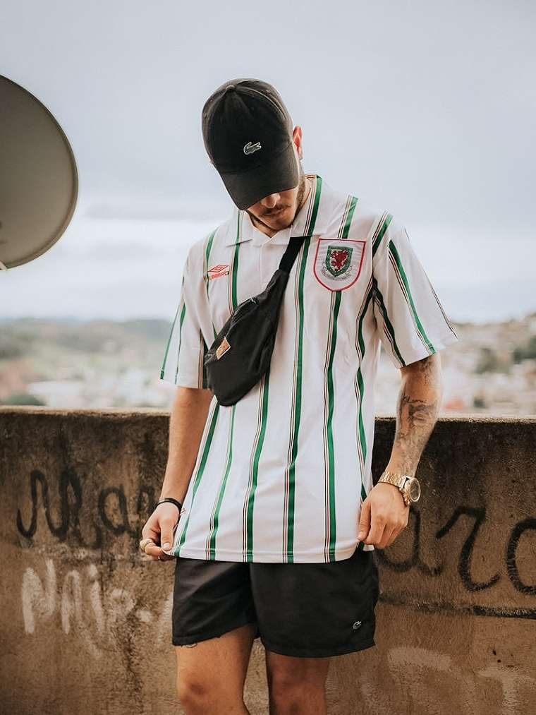 Rapaz de boné preto vestindo camisa retrô branca com listras verdes